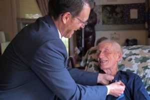 Maryland Del. Justin Ready pins the Air Medal on the shirt of George Keeney.