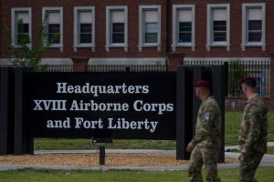 Soldiers walk past a newly unveiled sign after a redesignation ceremony officially renaming the military installation Fort Liberty