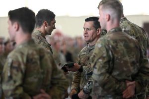 Command Sergeant Major Michael R. Weimer, Command Sergeant Major, U.S. Army Special Operations Command, presents a green beret