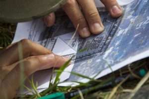 Spc. Christopher Moreno uses a protractor to determine an azimuth during the land navigation test of the Basic Leader Course.