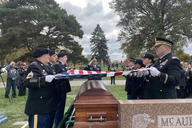 Servicemen lay Lt. Edward T. McGuire's remains to rest