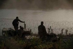 Texas National Guard members block migrants from crossing the Rio Grande