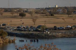 A group of migrants wades through the Rio Grande