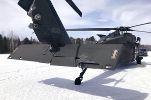 Damaged Black Hawk helicopter resting in the snow