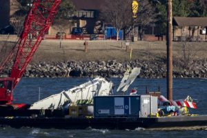 A piece of wreckage is lifted from the water onto a salvage vessel, near the site in the Potomac River of a mid-air collision