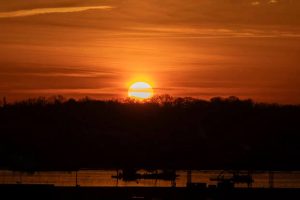 The sun rises above a wreckage site in the Potomac River
