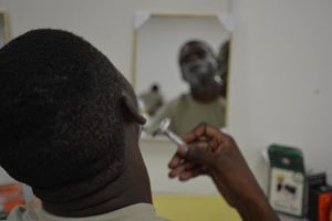 A soldier uses a single-blade razor to shave his face