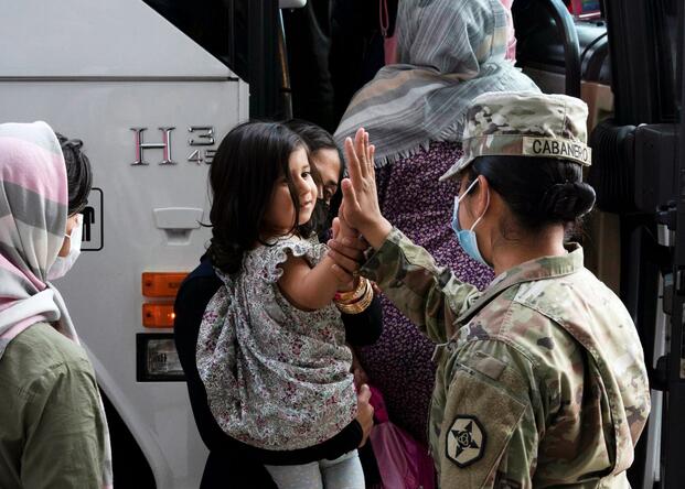 Army soldier gives a high five to a small child from Afghanistan.