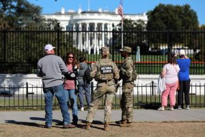 People talk with National Guard soldiers on the Ellipse.
